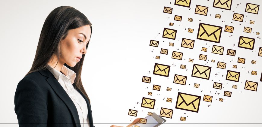 A woman holding a cell phone with cartoon icons of yellow envelops floating out and all around it.