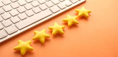 A keyboard with five stars underneath it, on an orange background.